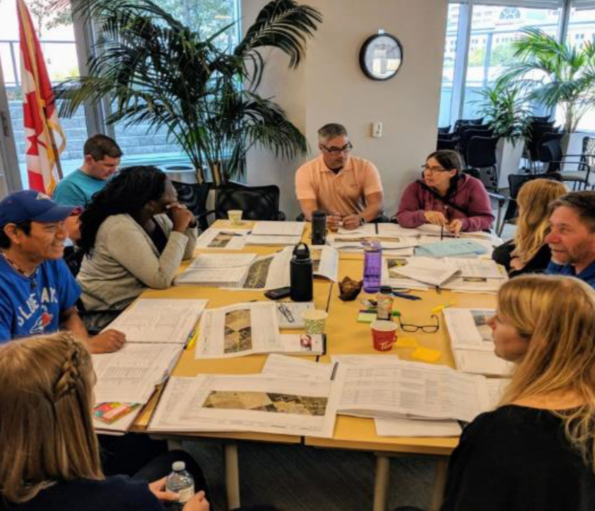Nine people working around a table