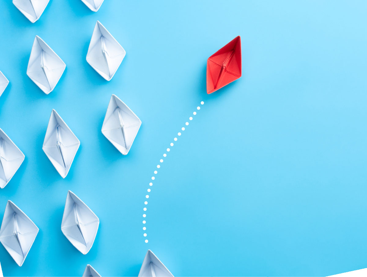 An image of red and white paper sail boats on a blue background
