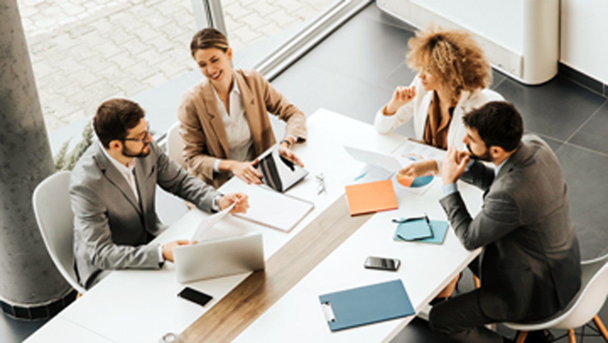 Four people sitting at a table talking.