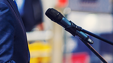A close up of someone standing in front of microphones