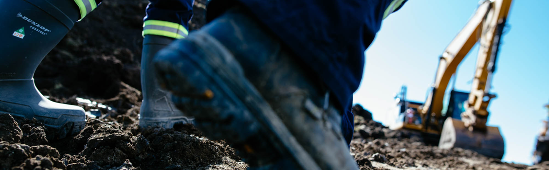 Work boots in the foreground and construction site in the background