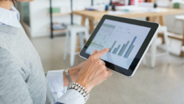 Gros plan d’une personne qui passe en revue des graphiques sur une tablette.