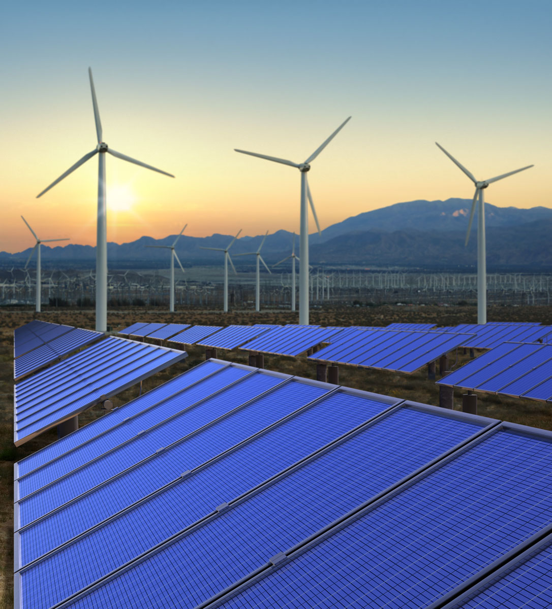 Des panneaux solaires et des éoliennes au coucher du soleil.