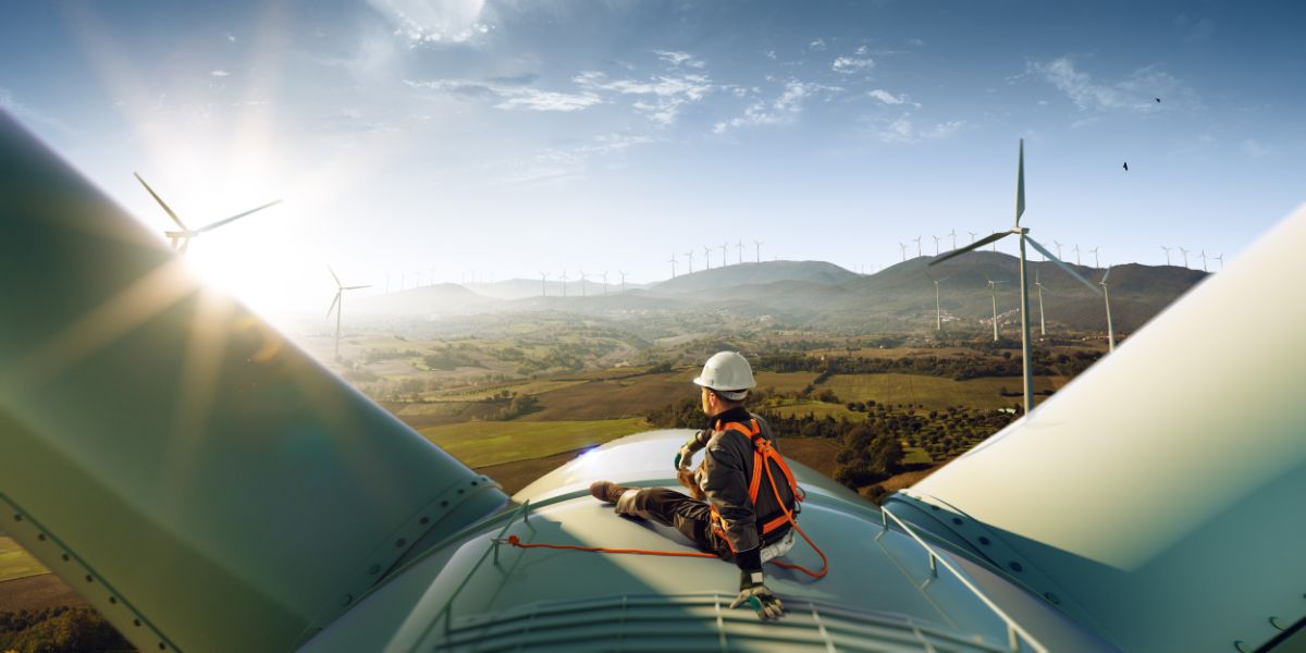 Travailleur assis sur une éolienne.