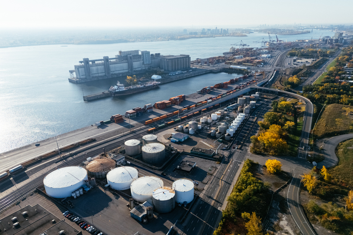 Aerial view of port industrial oil and product storage tanks and container yard near river in Montreal, Canada. 