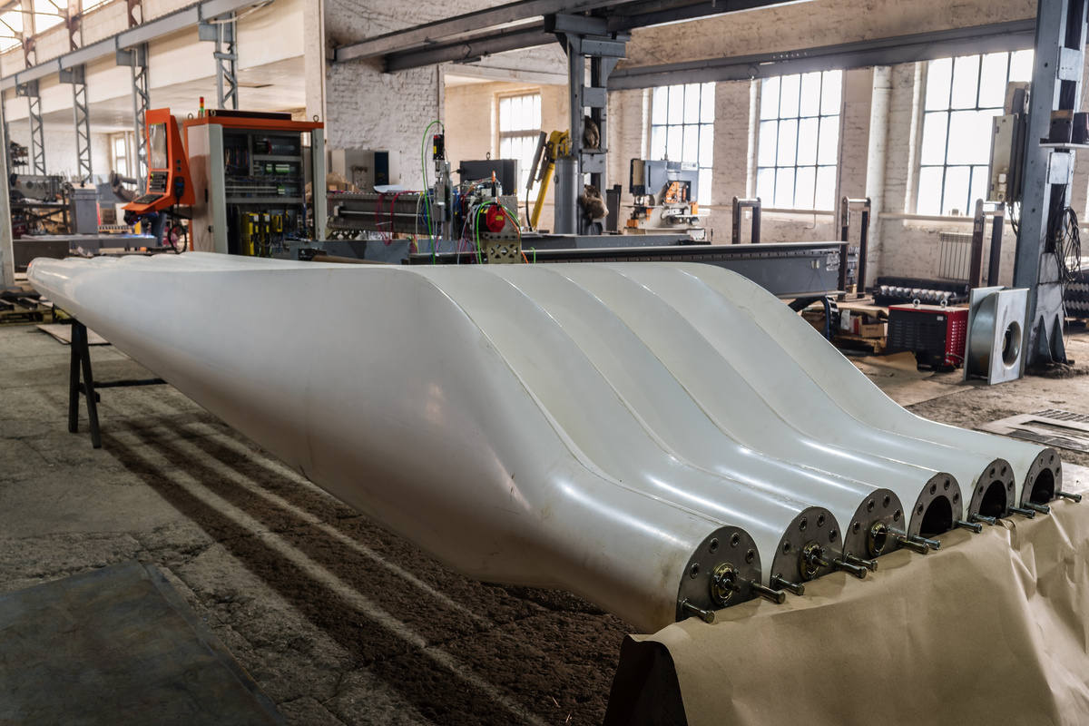 Two sets of freshly made blades for wind turbines on factory floor in Orenburg region of Russia. 