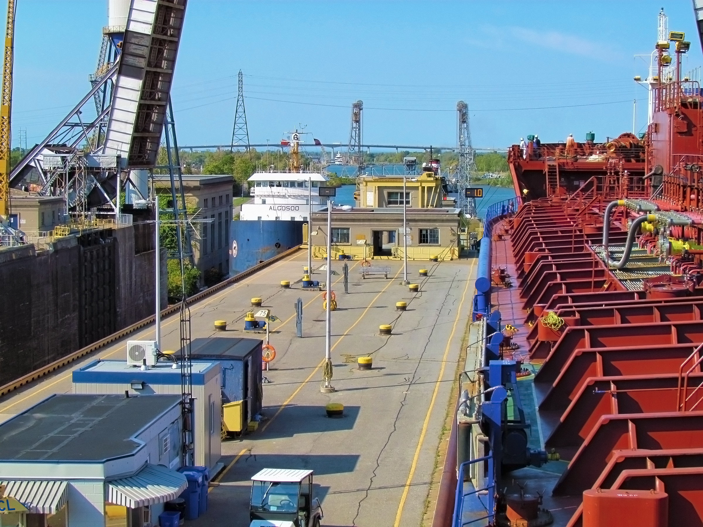 St. Lawrence Seaway; big tankers ship oil passing through the river locks system. Sunny day landscape.