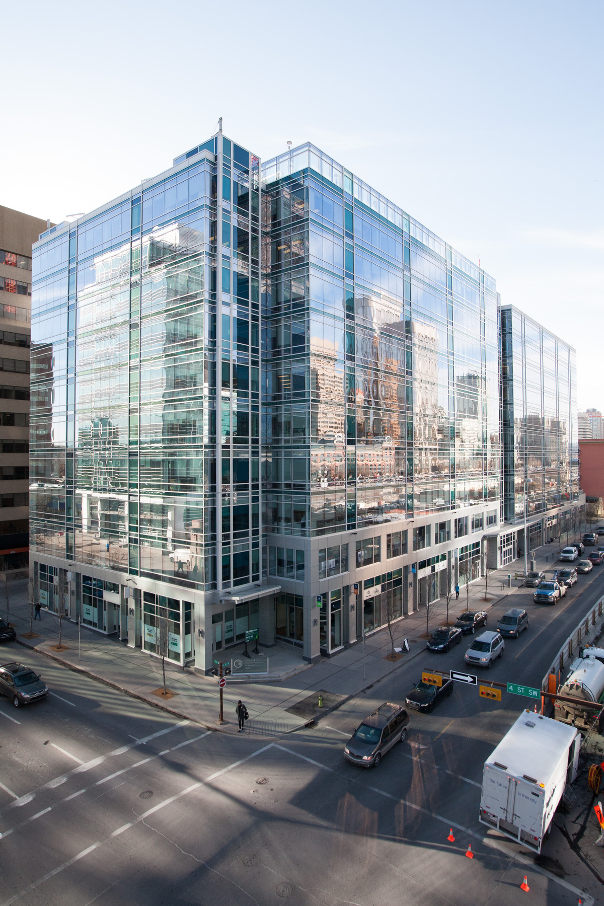 Centre10, the building the Canada Energy Regulator has offices in, reflects the Calgary downtown skyline in its windows and the street below.