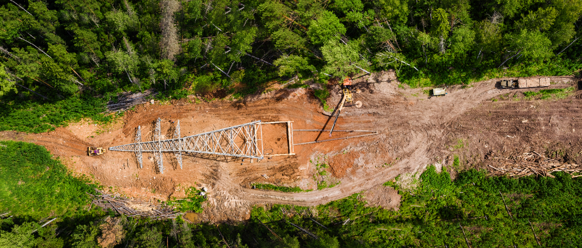 Aerial view of an electrical power line being constructed in a boreal forest.