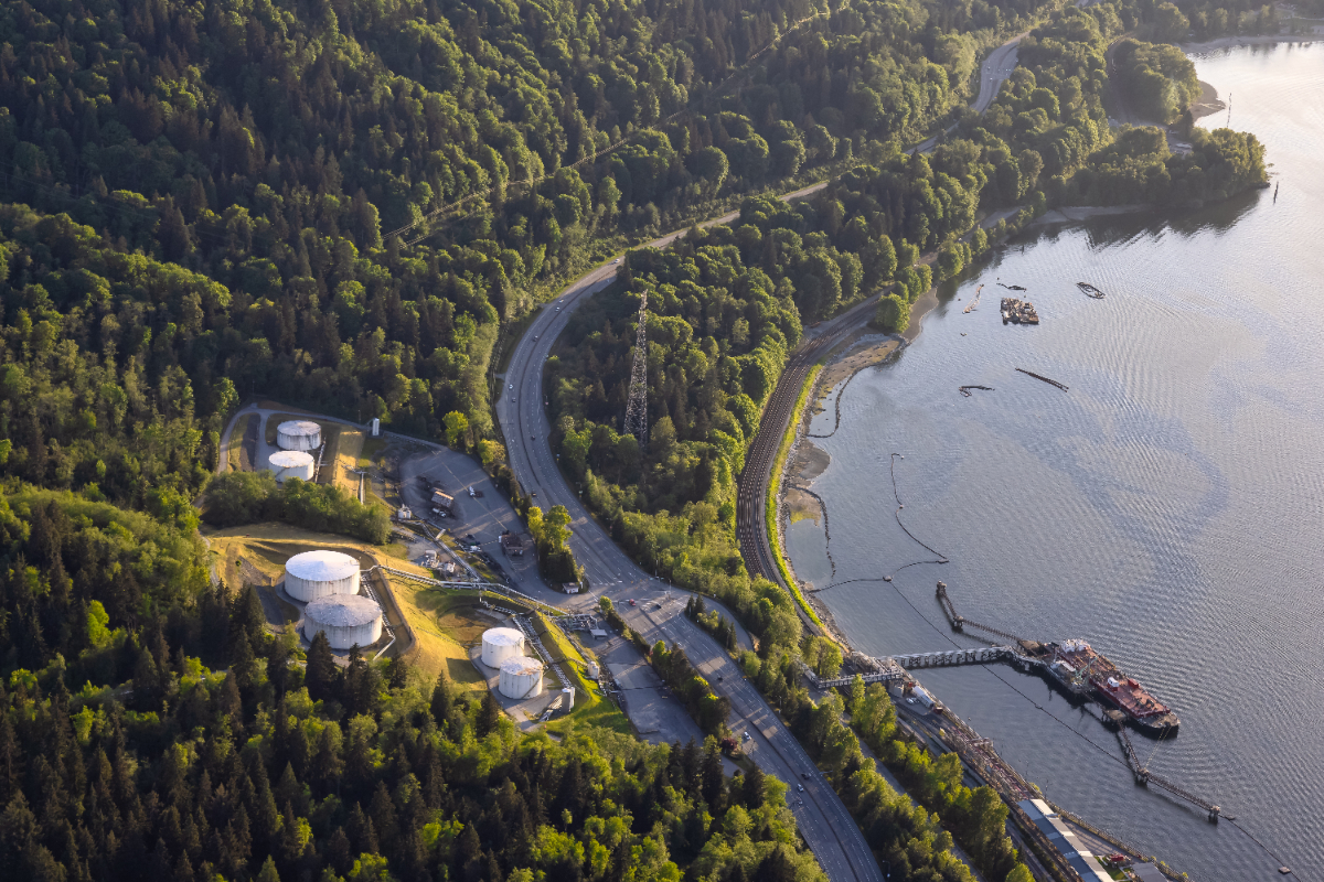 Aerial view of oil refinery industrial site and tanker loading port during a vibrant spring sunny day. Taken in Port Moody, Vancouver, BC, Canada.