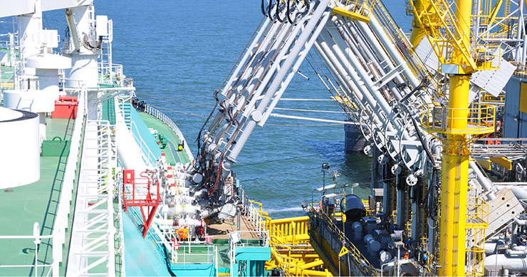 Un méthanier déchargé de sa cargaison au moyen d’une grue à composantes multiples reliée au pipeline du terminal