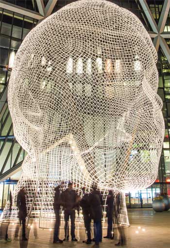 Photo&nbsp;: Personnes réunies en soirée devant la sculpture «&nbsp;Wonderland&nbsp;» de Jaume Plensa