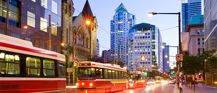 Electric street cars at dusk in downtown Toronto on a summer evening.