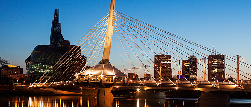 Le soleil vient de se coucher sur le musée canadien des droits de la personne et le pont Esplanade Riel à Winnipeg, au Manitoba. 