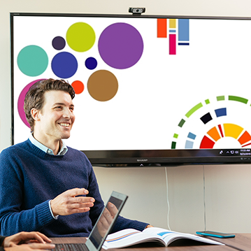 Employé de la Régie pendant une réunion, écran montrant un graphique de données interactives.