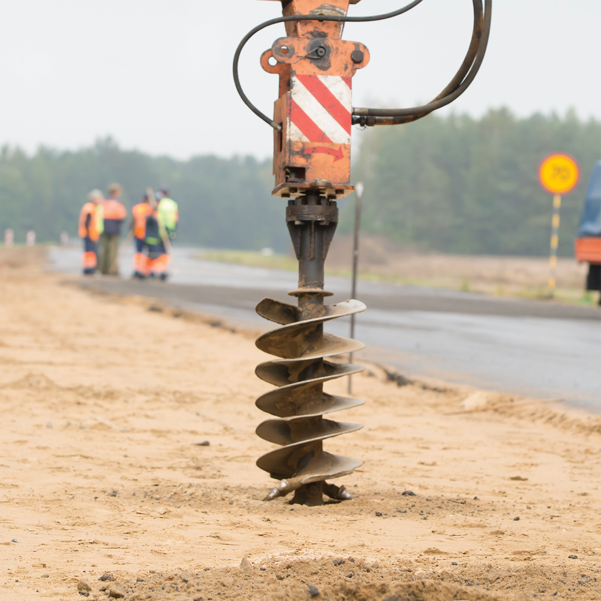 Tarière mécanique creusant des trous pour les poteaux sur un chantier de construction