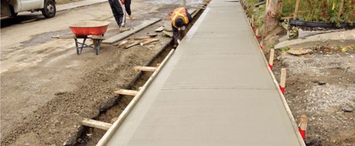 Stakes for concrete forms with marks at 29&nbsp;cm on sidewalk construction