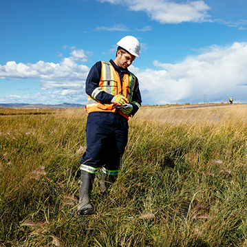 CER employee in the field wearing personal protective equipment taking notes